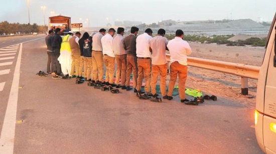 Grupo de hombres orando en una carretera